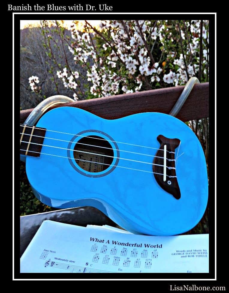 Banish the Blue with Dr. Uke by Lisa Nalbone blue dolphin ukulele in sunset on deck with almond blossoms and What a Wonderful World music.